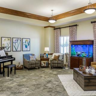 A cozy living room featuring a piano, an aquarium, and comfortable seating with stylish decor.
