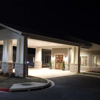 A well-lit building entrance with a covered walkway at night.