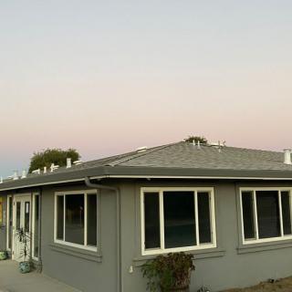 Sunset view of a residential house with large windows.