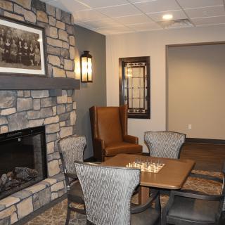 A cozy living room with a stone fireplace and comfortable seating.