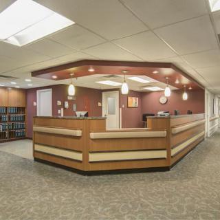 A modern reception area with a wooden counter and overhead lighting.