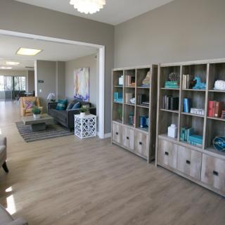 A modern living room with bookshelves and comfortable seating in an open, well-lit space.