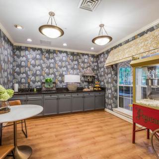 A stylish kitchen interior featuring modern wallpaper, a wooden floor, and a popcorn machine.