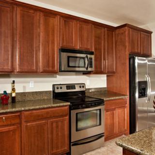 Modern kitchen with wood cabinets and stainless steel appliances.