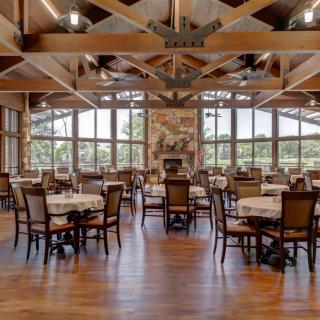 Spacious dining area with large windows and wooden interior.