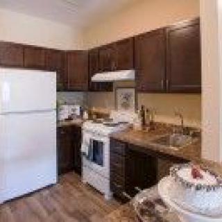 A compact kitchen with dark cabinets and white appliances.