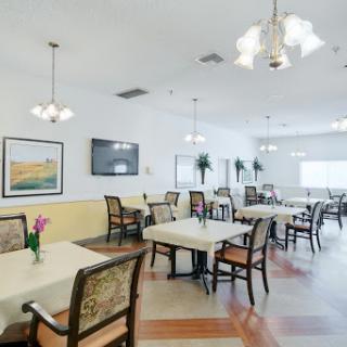 A spacious and well-lit dining area with neatly arranged tables and chairs, perfect for social gatherings.
