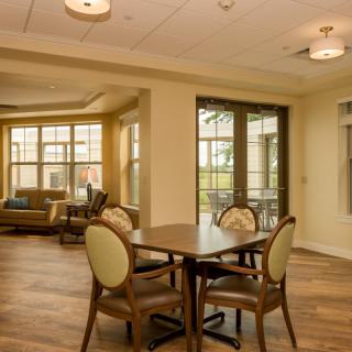 A cozy, well-lit living space with a dining area and large windows.