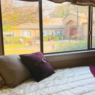 A cozy bedroom with a large window showcasing a view of the outside.