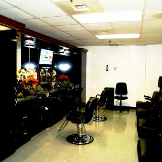 Interior view of an empty hair salon with multiple chairs and mirrors.