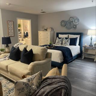 A stylish bedroom with an adjacent living area, featuring a cozy sofa and a well-appointed bed.