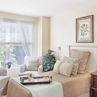 A cozy bedroom with neutral tones and ample natural light.