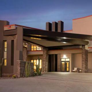 A modern building entrance illuminated in the evening.