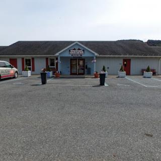 A view of a commercial building with a blue door and parking spaces in front.