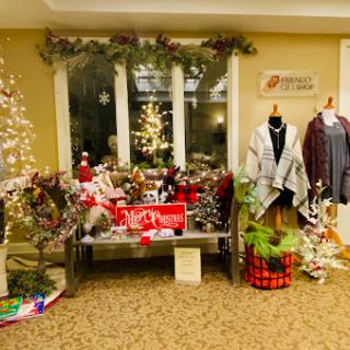 A cozy holiday shopping display featuring festive decorations, clothing, and gift items.