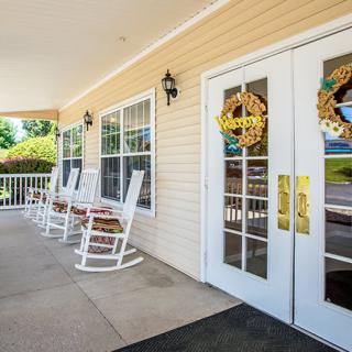 A welcoming porch with rocking chairs and decorative doors.