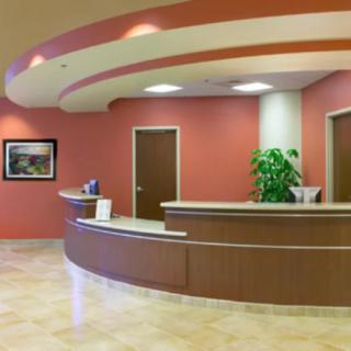 A modern reception area with a curved desk, neutral tones, and contemporary decor.