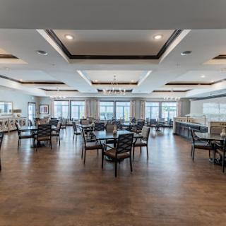 A spacious and modern dining area featuring elegant furniture and large windows that provide ample natural light.