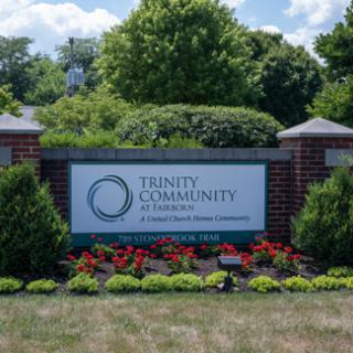 Entrance sign for Trinity Community, surrounded by well-maintained landscaping.