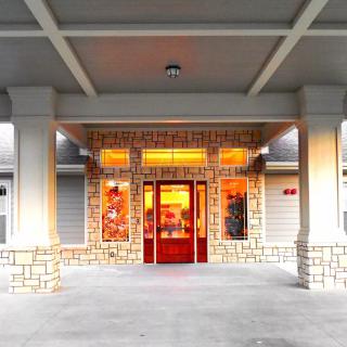 A brightly lit building entrance with a red door.