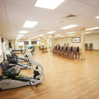 A spacious gym interior with exercise equipment and seating area.