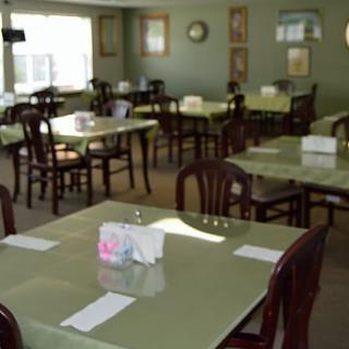 An empty restaurant dining area with tables and chairs neatly arranged.
