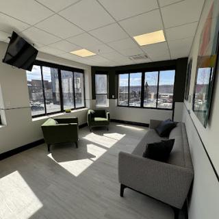 A bright and modern lounge area with comfortable seating and large windows.