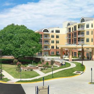 A modern residential complex surrounded by landscaped grounds and a clear blue sky.