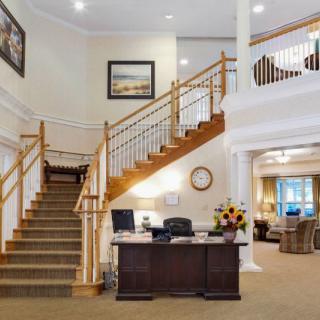 A welcoming office lobby with a reception desk and staircase.