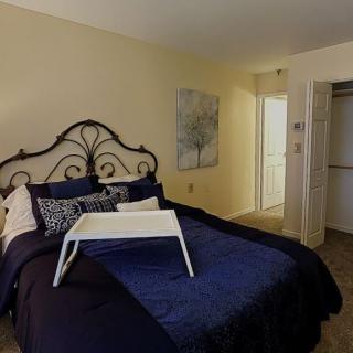 A cozy bedroom with a decorative bed and a tray table on top.