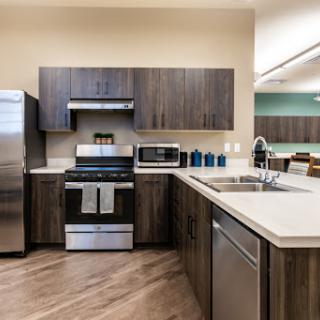 A modern kitchen featuring stainless steel appliances and sleek wooden cabinetry.