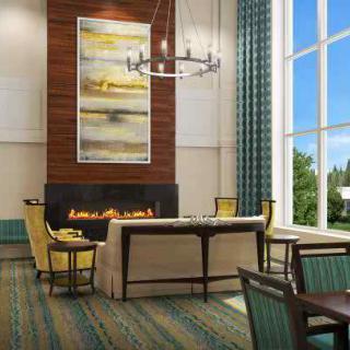 A modern lobby with a cozy seating area around a fireplace.