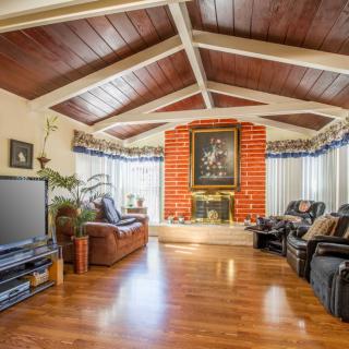 Spacious living room with a vaulted ceiling and brick fireplace.