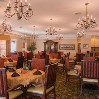 An elegant dining room with chandeliers and neatly arranged tables.
