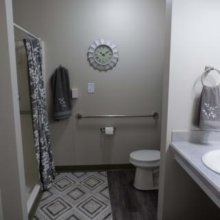 A modern bathroom featuring a shower, toilet, and stylish decor.