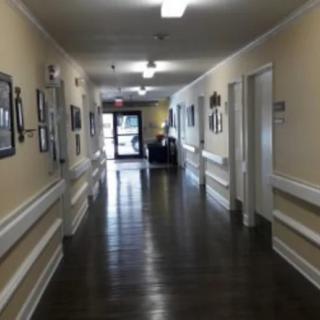 An empty hallway inside a building with framed pictures on the walls.