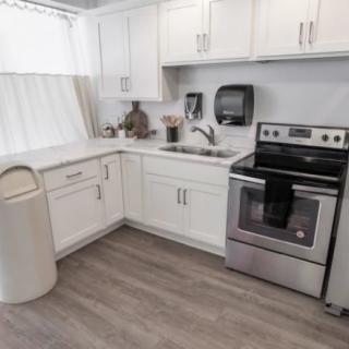 A modern kitchen with white cabinets and stainless steel appliances.