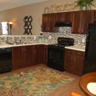 Modern kitchen with dark cabinetry and tile backsplash.