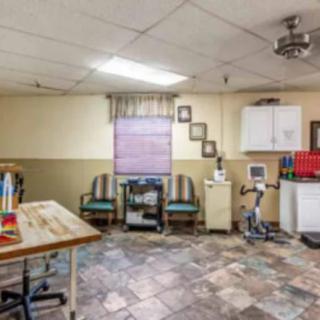 A multi-purpose room with seating, exercise equipment, and tiled flooring.