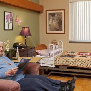 An elderly woman relaxing in a comfortable room at a nursing home.