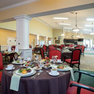 An elegantly set dining room with neatly arranged tables and chairs.