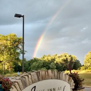 A beautiful rainbow arcs over a lush landscape, bringing a touch of color to the scene.