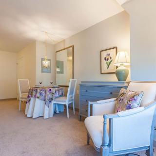 A cozy living room with a small dining setup, featuring elegant furniture and tasteful decor.