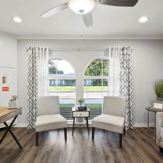 A modern living room with sleek armchairs and large windows allowing natural light to fill the space.