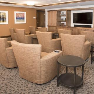 A modern conference room with comfortable seating and a large television.