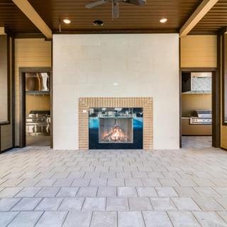 A modern living room with a central fireplace, surrounded by elegant decor and warm lighting.
