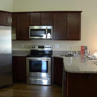A modern kitchen with stainless steel appliances and wooden cabinets.