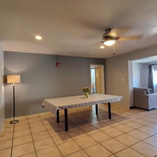 A spacious living room with a dining table, sofa, and modern decor.