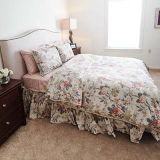 A cozy bedroom with floral-patterned bedding and a soft, inviting atmosphere.