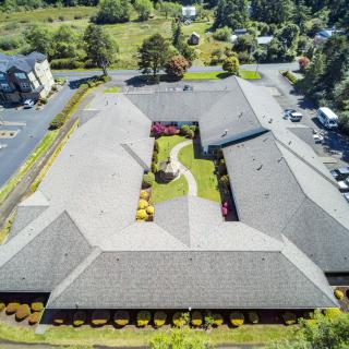 Aerial view of a large building with a central courtyard surrounded by greenery.